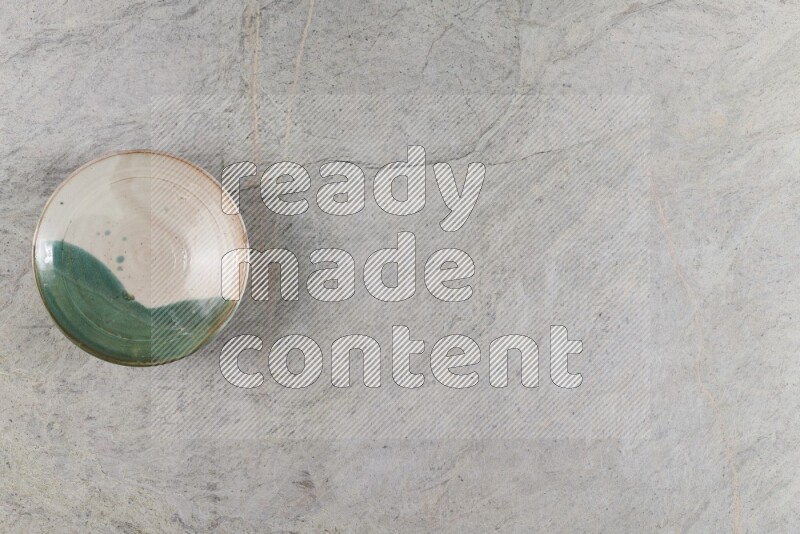 A decorative pottery plate on grey marble background