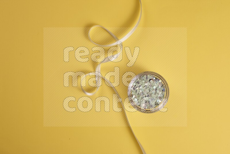 مجموعة من أدوات الخياطة والتفصيل خضراء اللون على خلفية صفراء