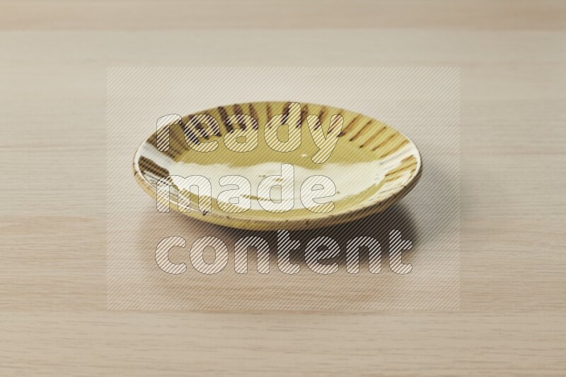 A multicolored pottery plate on light wooden background