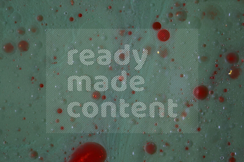 The image captures a dramatic splatter of red paint over a green backdrop