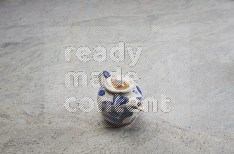 A pottery teapot on grey marble background