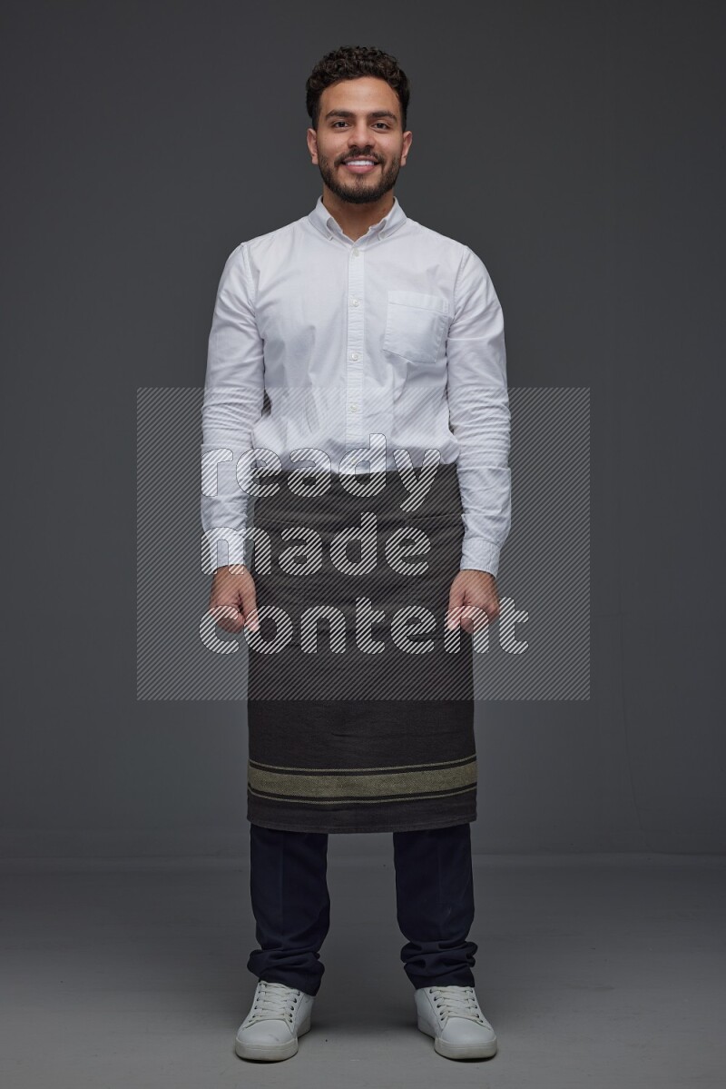 A man wearing smart casual and apron standing and making multi poses eye level on a gray background