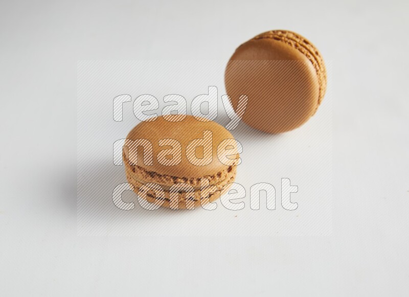45º Shot of two Brown Maple Taffy macarons on white background