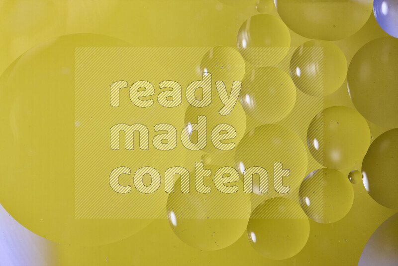 لقطات مقربة لفقاعات من الزيت على سطح الماء باللون الأصفر