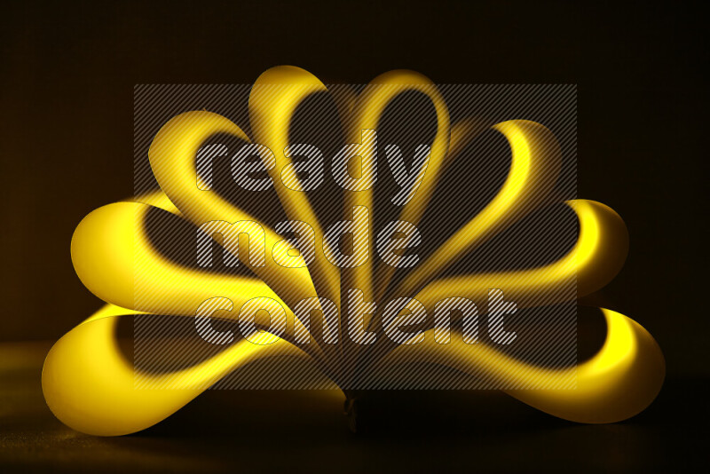 An abstract art piece displaying smooth curves in yellow gradients created by colored light