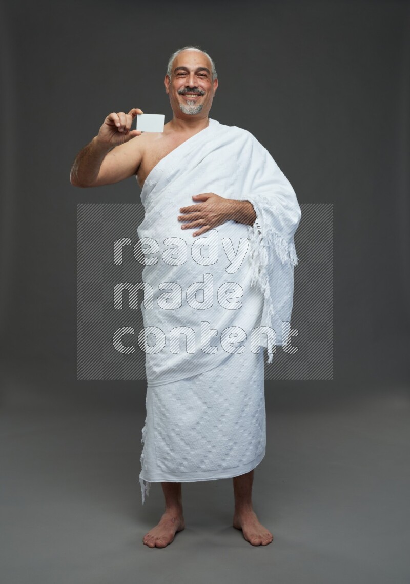 A man wearing Ehram Standing holding ATM card on gray background
