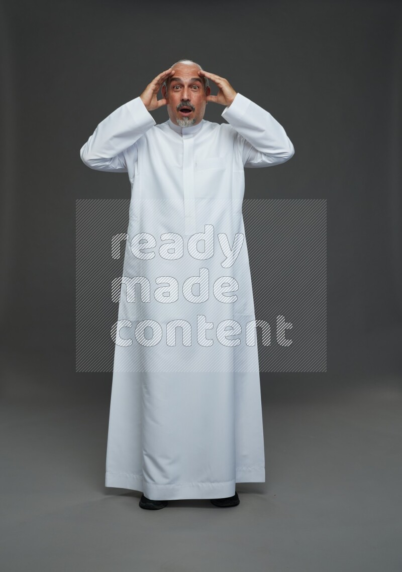 Saudi man without shomag Standing Interacting with the camera on gray background