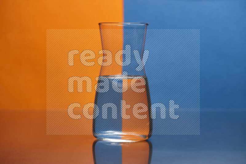 The image features a clear glassware filled with water, set against orange and blue background