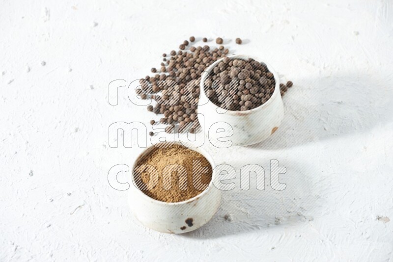 2 beige bowls, one full of powder and the other full of whole balls with balls and powder spreaded on a textured white flooring