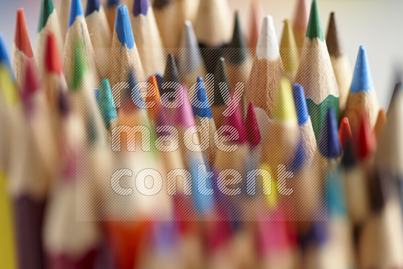 The image captures a close-up of sharpened colored pencils on multicolored background
