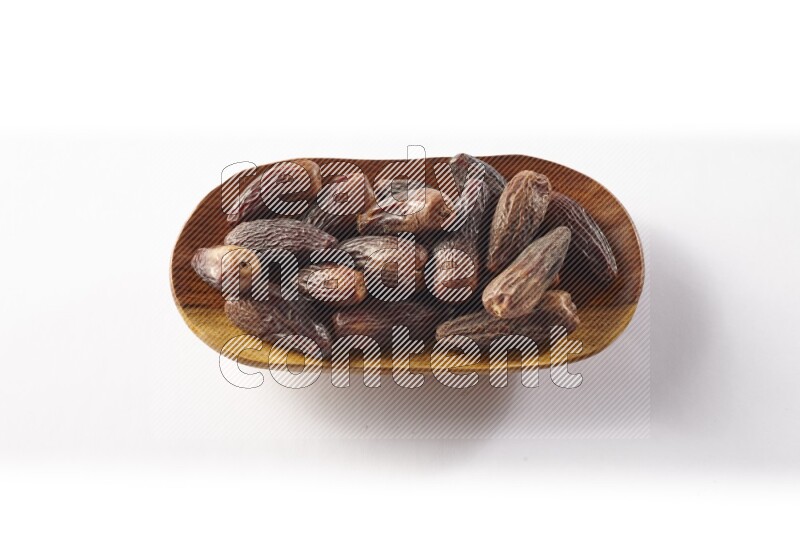 Dates in a wooden plate on white background