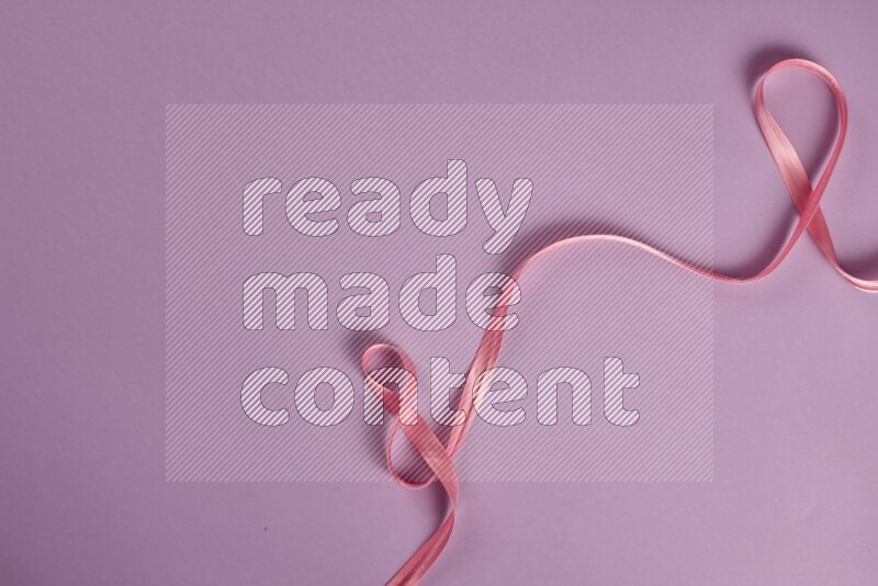 A pink and purple collection of sewing and tailoring tools arranged on a purple background