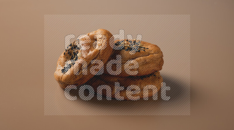 Hasawi cookies field with date and decorated by black seed and Anise grain on a brown background