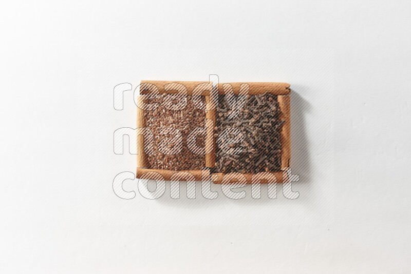 2 squares of cinnamon sticks full of cloves and flaxseeds on white flooring