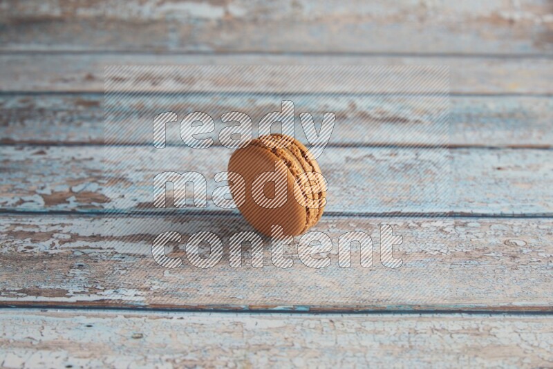 45º Shot of Brown Maple Taffy macaron on light blue wooden background