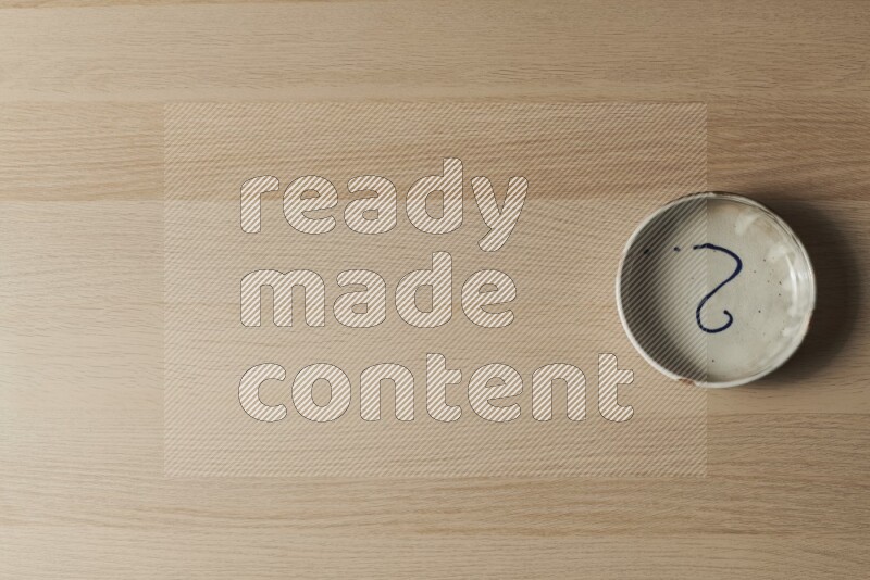 A multicolored pottery bowl on light wooden background