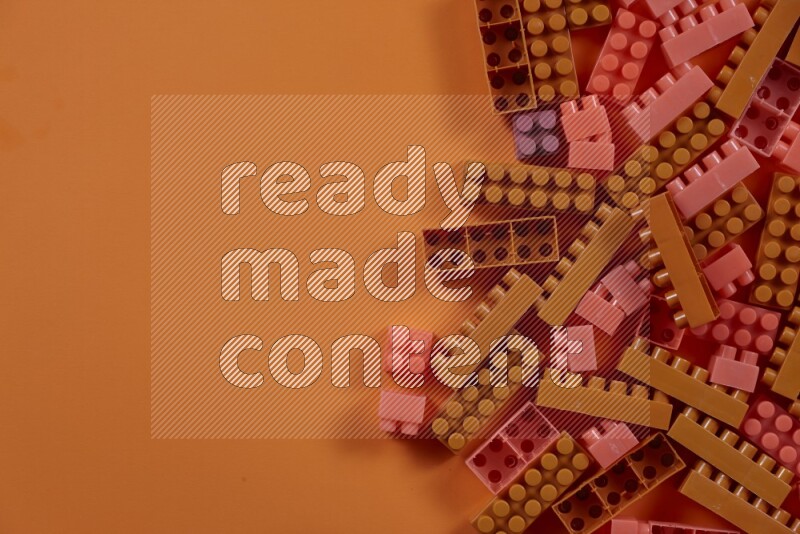 Orange plastic building blocks on orange background (kids toys)