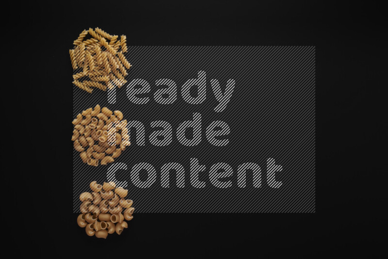 Different pasta types in 3 bunches on black background