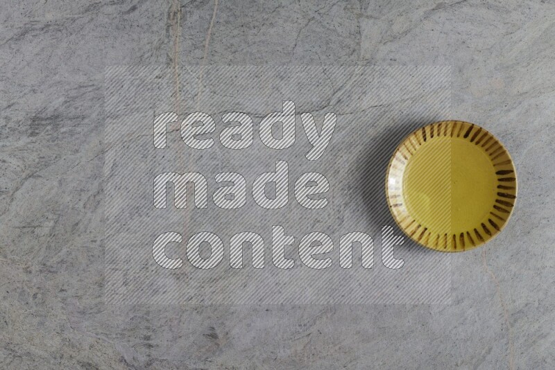 A multicolored pottery plate on grey marble background