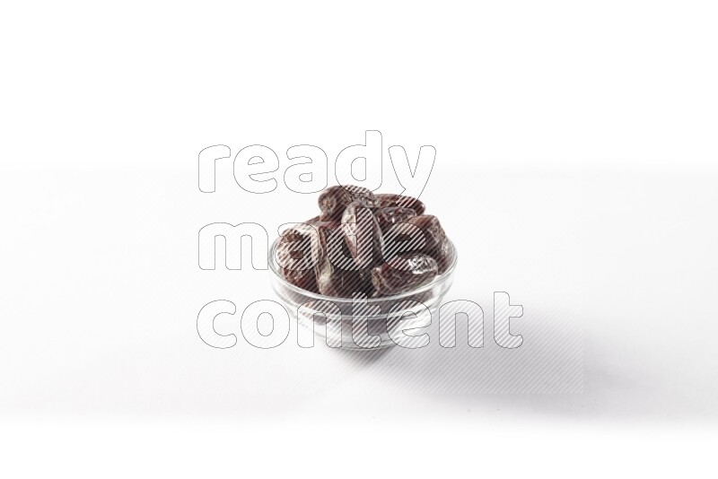 Dates in a glass bowl on white background