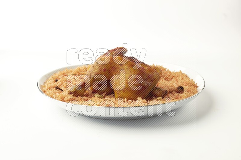 red basmati Rice with  kabsa chicken pieces on a white plate with a silver rim direct  on white background
