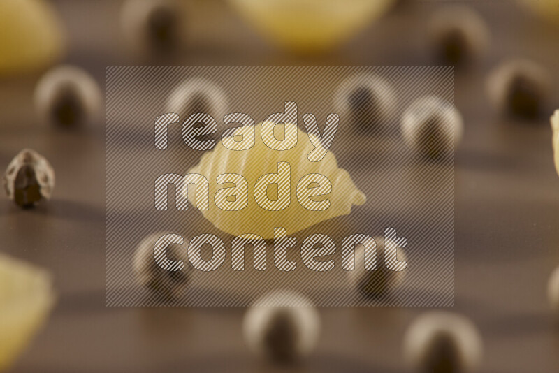 معكرونة مع مكونات متنوعة من الطماطم والثوم والبصل والفلفل الأحمر والفلفل الأسود والفلفل الأبيض وأوراق الغار وإكليل الجبل والهيل على خلفية بيج