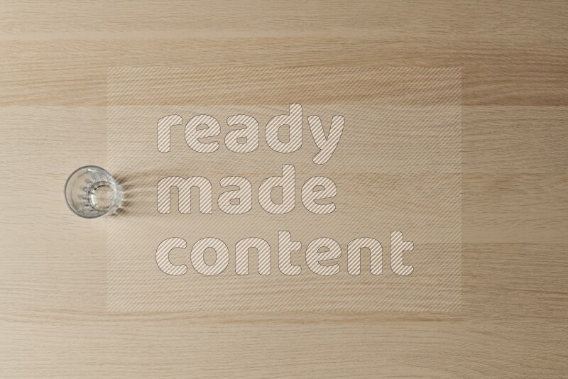 An empty glass cup on light wooden background