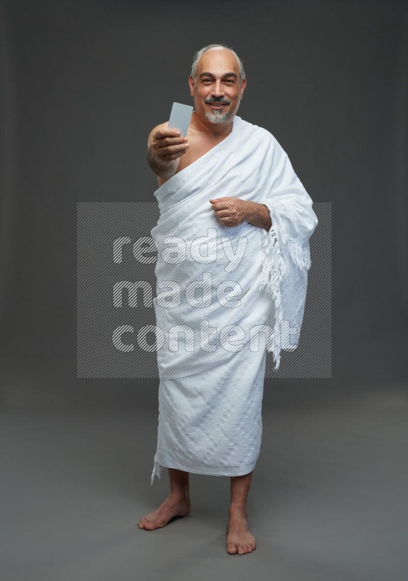 A man wearing Ehram Standing holding ATM card on gray background