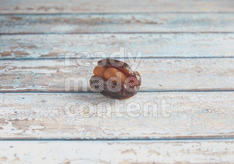 almond stuffed madjoul date on a light blue wooden background