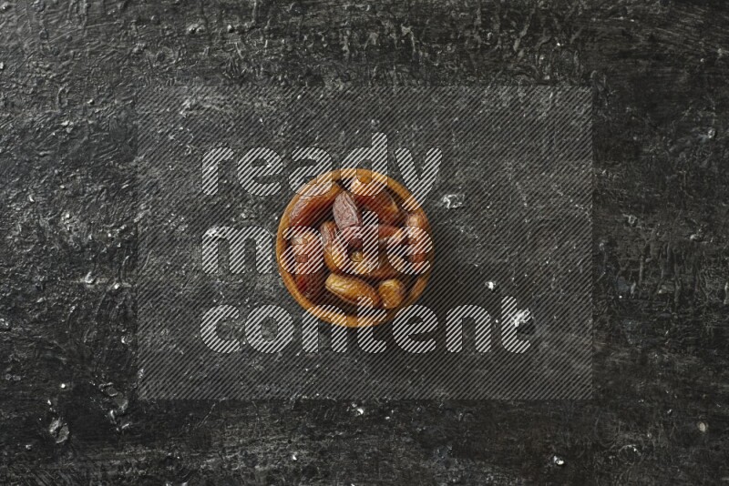 تمر في أطباق خشبية علي خلفية سوداء