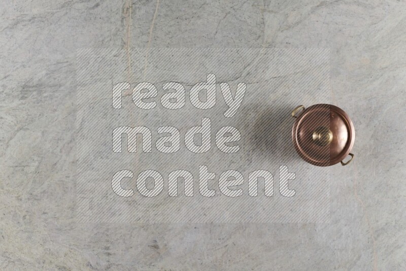 وعاء نحاسي صغير على خلفية من الرخام الرمادي