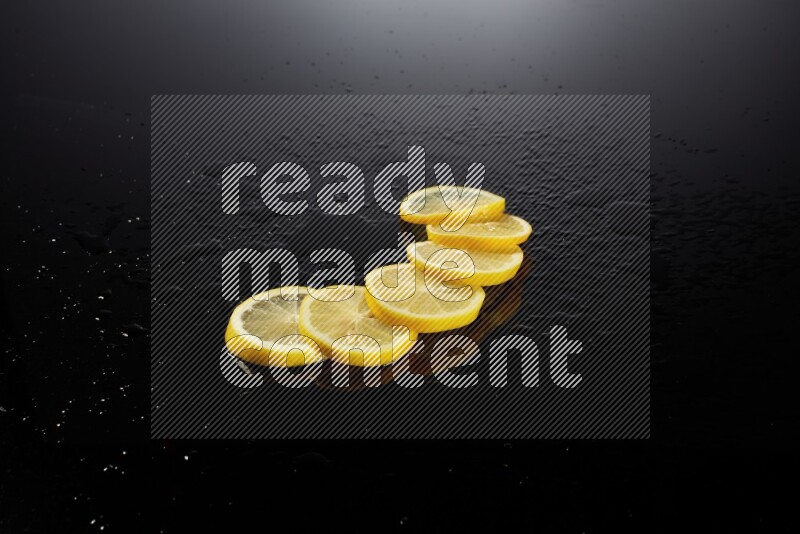 Lemon slices with water drops, and droplets on black background