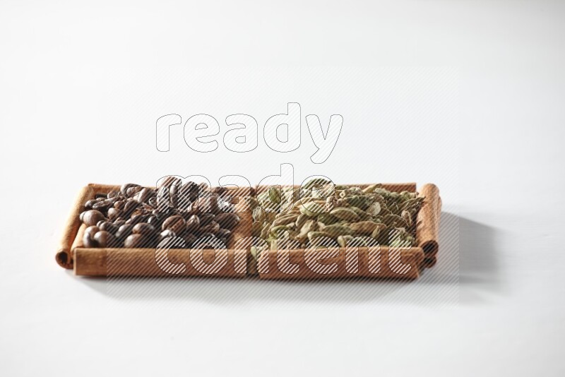 2 squares of cinnamon sticks full of cardamom and coffee beans on white flooring