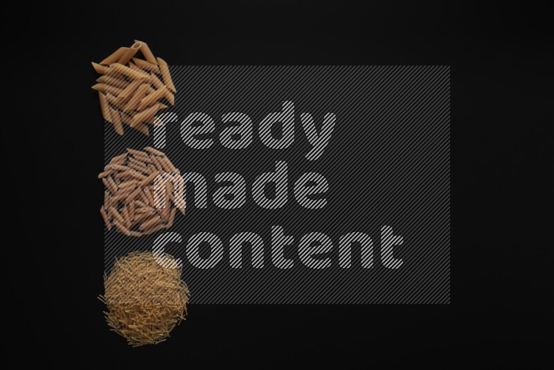 Different pasta types in 3 bunches on black background