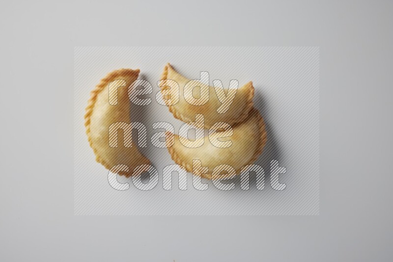 Three fried sambosa from a top angle on a white background