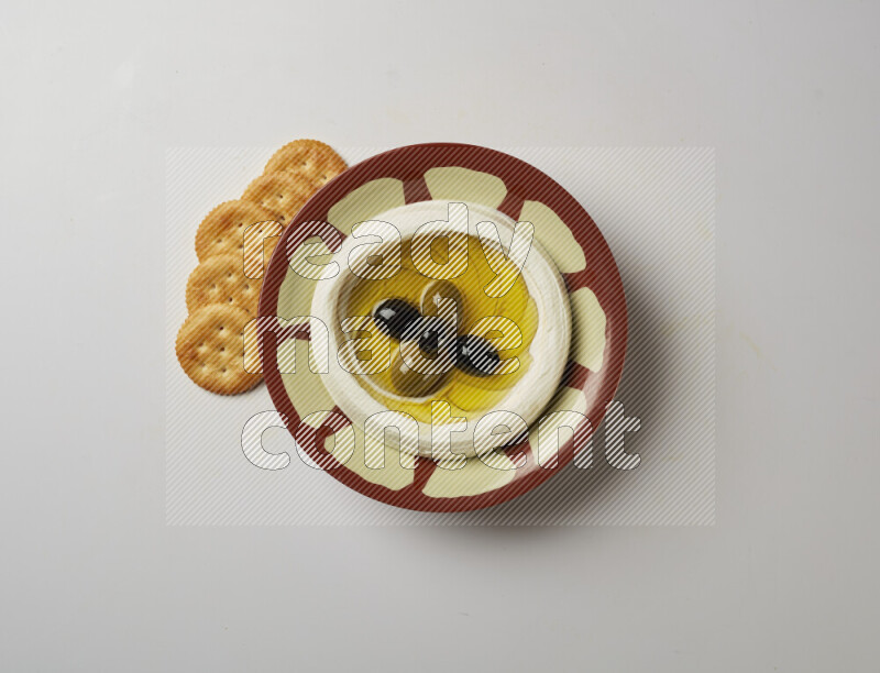 Lebnah garnished with olives in a traditional plate on a white background