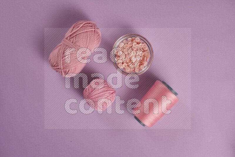 مجموعة من أدوات الخياطة والتفصيل زهرية وأرجوانية اللون على خلفية أرجوانية