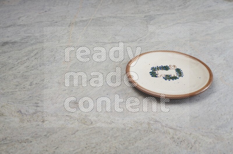 A decorative pottery plate on grey marble background