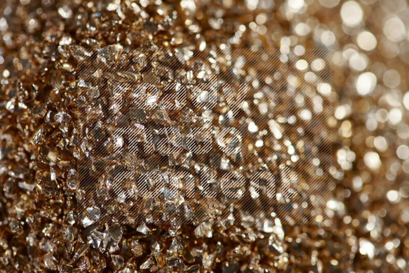 Gold shimmering fragments of glass scattered on a black background