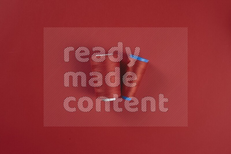 A red collection of sewing and tailoring tools arranged on a red background