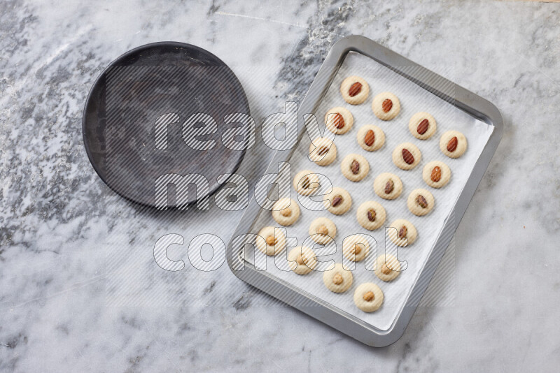 غريبة خطوة بخطوة بالمكونات الدقيق والسكر البودرة والسمن والمكسرات على خلفية رخام رمادي