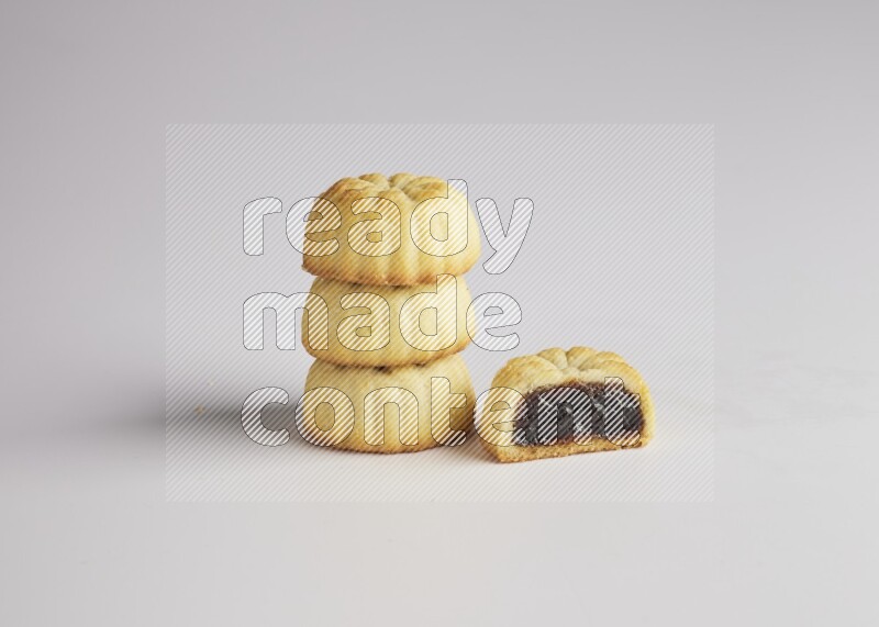 Four Pieces of Maamoul filled with date one of them is cut direct on white background