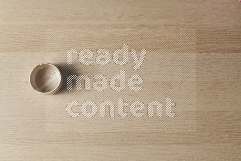 وعاء فخاري متعدد الألوان على خلفية خشبية فاتحة