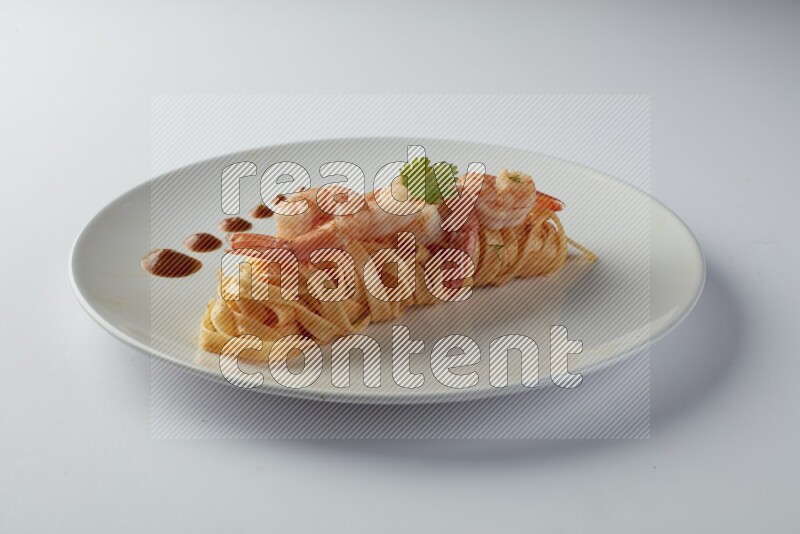 Fettuccini red sauce pasta with shrimp in a white plate on a white background
