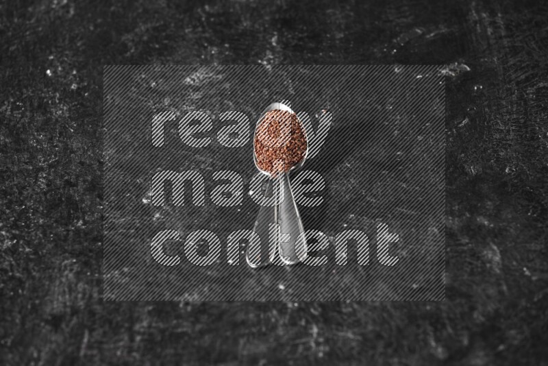 ملعقتان معدنيتان ممتلئتان ببذور حب الرشاد علي خلفية سوداء