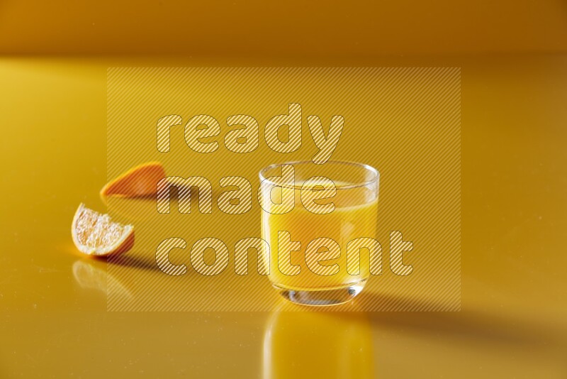 glass of orange juice on yellow background