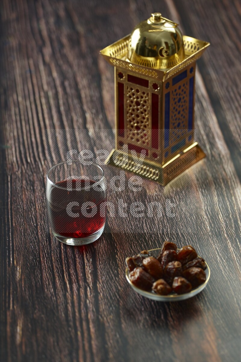 A golden lantern with different drinks, dates, nuts, prayer beads and quran on brown wooden background