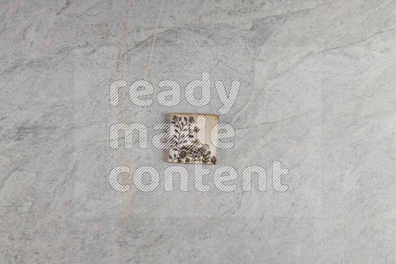 A decorative pottery coaster on grey marble background