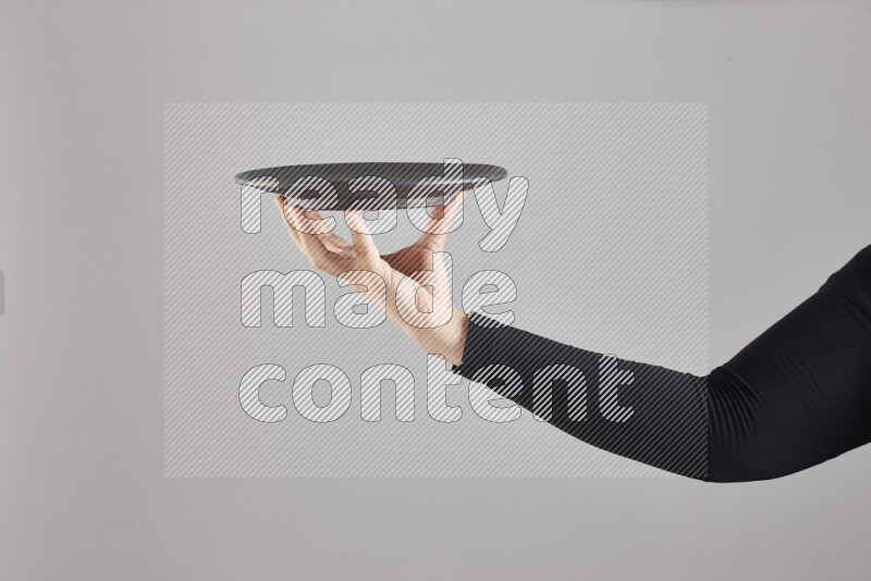 امرأة ترتدي عباءة سوداء تحمل أدوات فخارية مختلفة في أوضاع متعددة