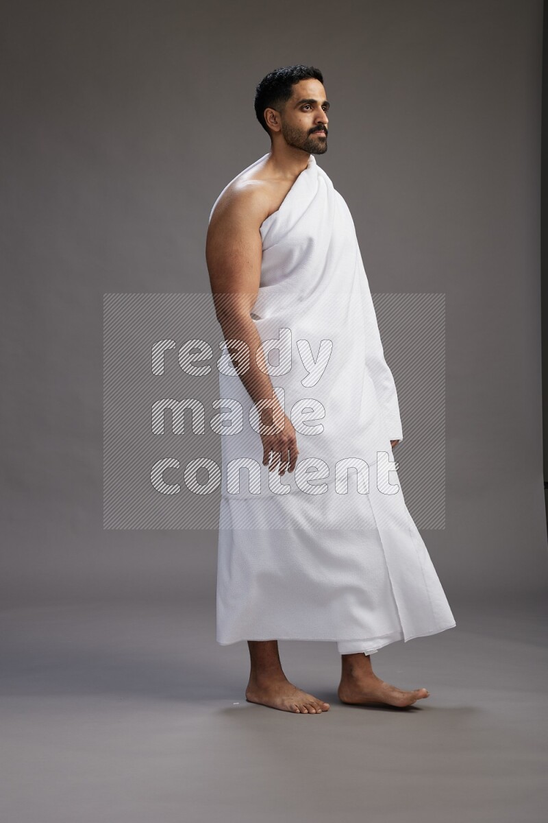 A man wearing Ehram Standing Interacting with the camera on gray background